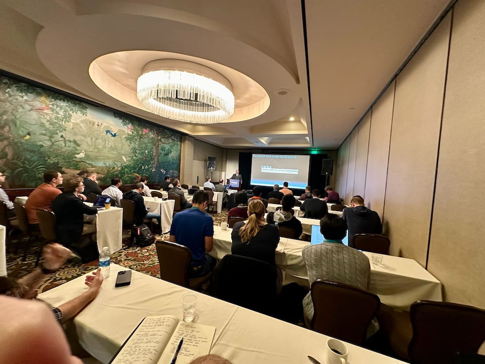 A diverse crowd seated at tables in a conference room
